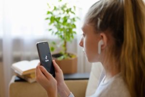 a girl watches the social network Tik Tok on her smartphone