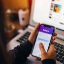 girl holding a iPhone with social Internet service Instagram on the screen.