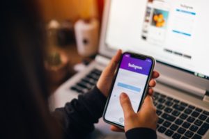 girl holding a iPhone with social Internet service Instagram on the screen.